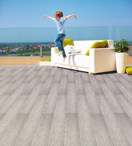 happy kid, boy jumping from the couch on roof top terrace at warm sunny day Otoczenie do potrzeb dzieci – Dom z myślą o najmłodszych
